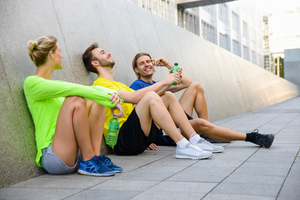 three friends sitting on floor wearing sports clothing medium